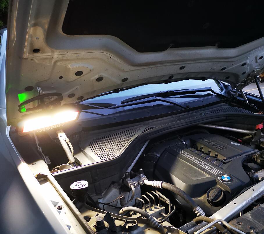Bright LED work light illuminating car engine bay for automotive repair tasks