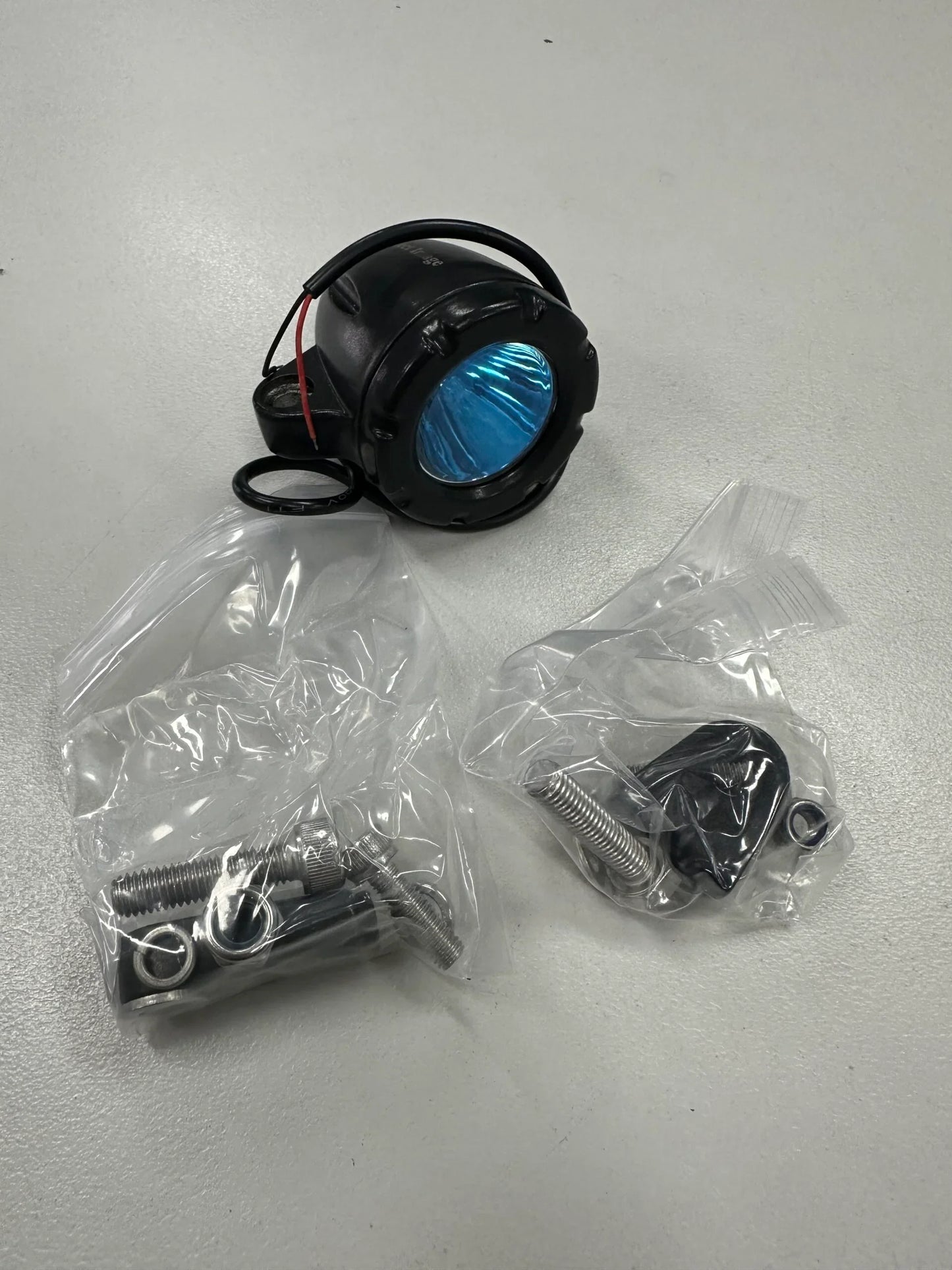 Black LED spotlight with blue lens and mounting hardware for marine or mining use
